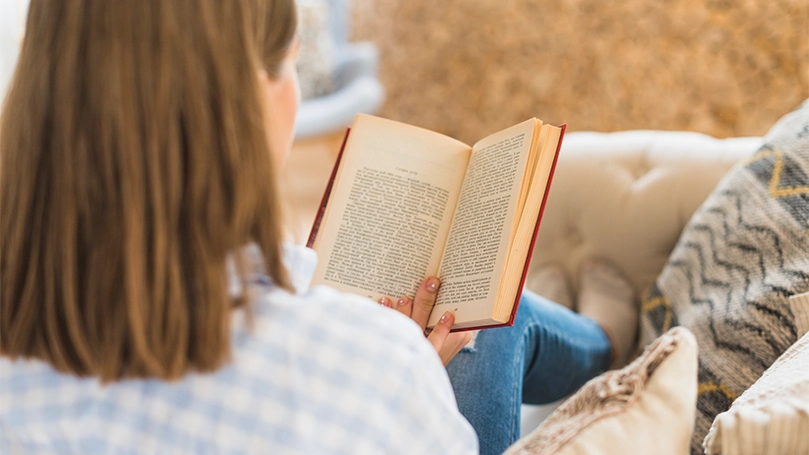 Een afbeelding van een vrouw die een boek leest