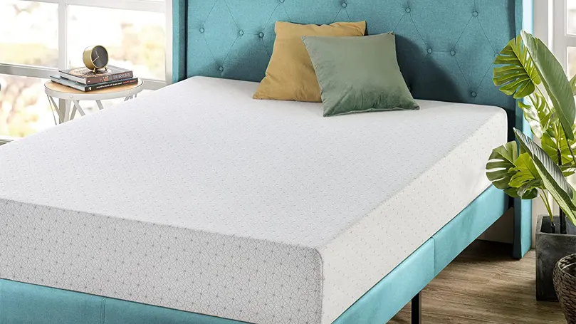 Een afbeelding van een traagschuim matras op een blauw bed.