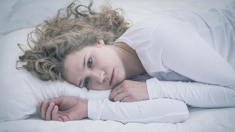 een afbeelding van een depressieve vrouw die in een bed ligt