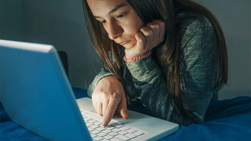 een beeld van een meisje dat 's nachts aan een computer werkt