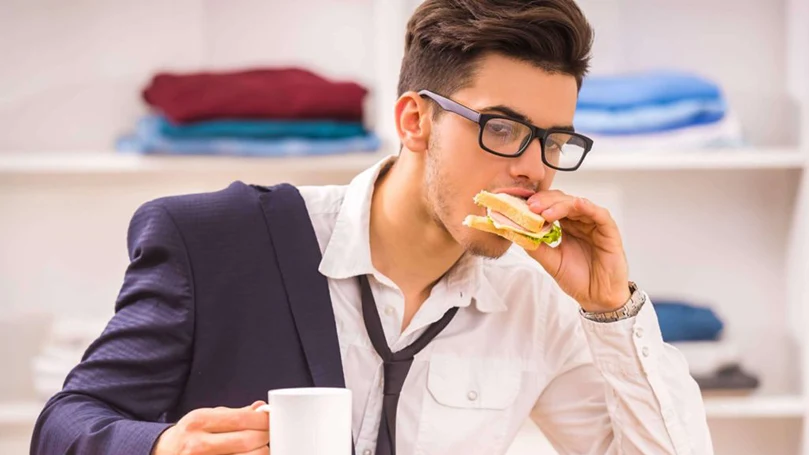 een beeld van een man die snel eet om op tijd op zijn werk te zijn