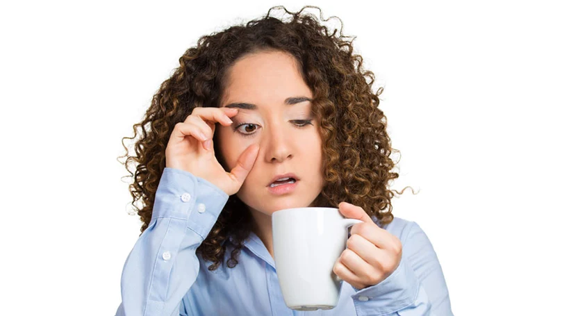 een afbeelding van een vrouw die koffie drinkt om wakker te blijven