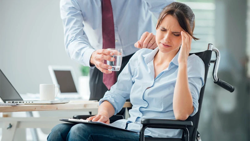 een afbeelding van een vrouw met migraine op het werk