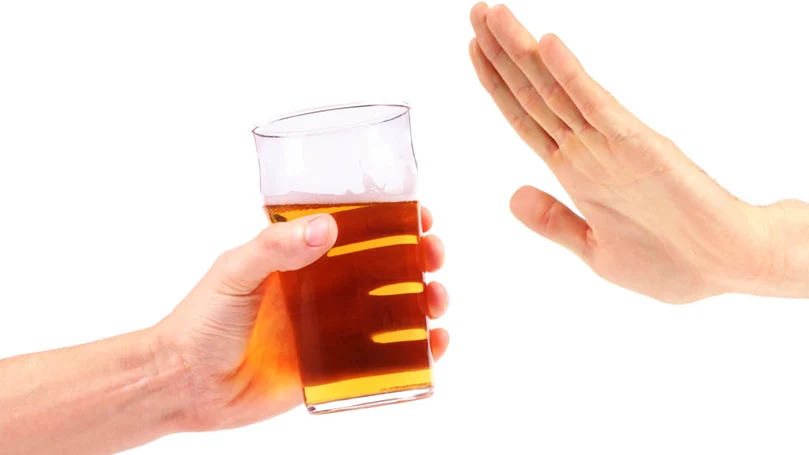 Een hand die weigert een glas alcohol te nemen