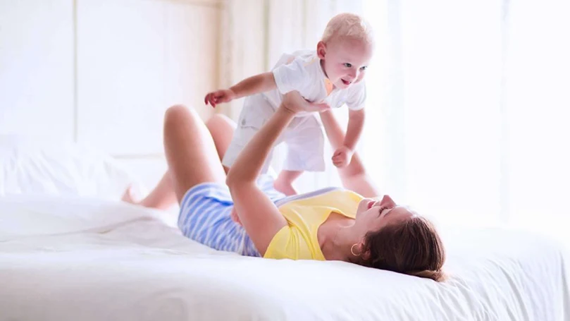 een afbeelding van een moeder die met haar baby speelt