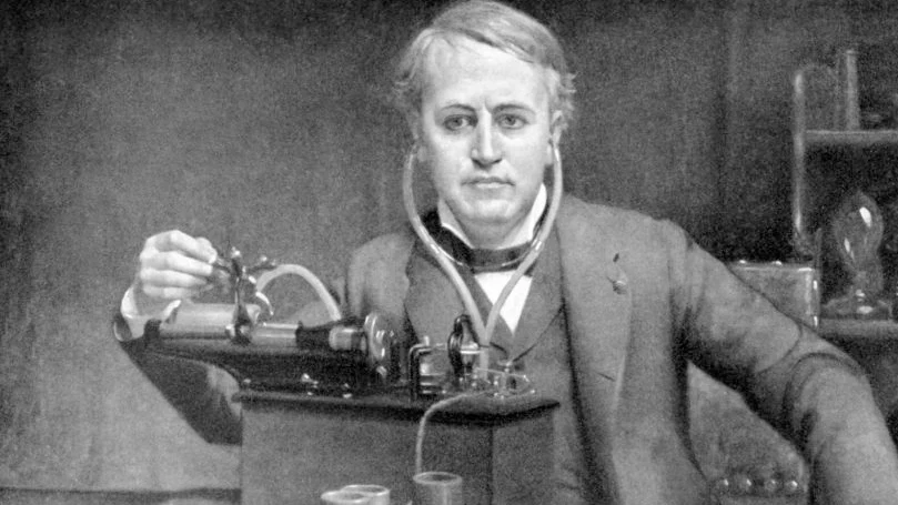 Een zwart-witfoto van Thomas Edison voor een machine