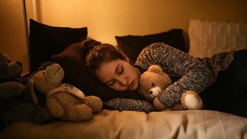 een vrouw slaapt in bed met het licht aan