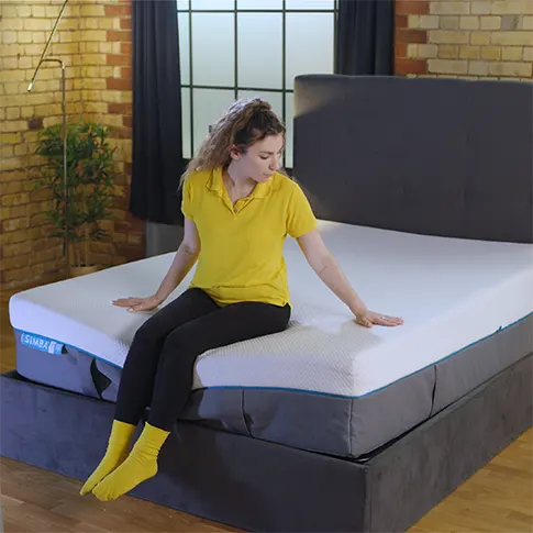 onze recensent zittend op het Simba Hybrid Luxe matras