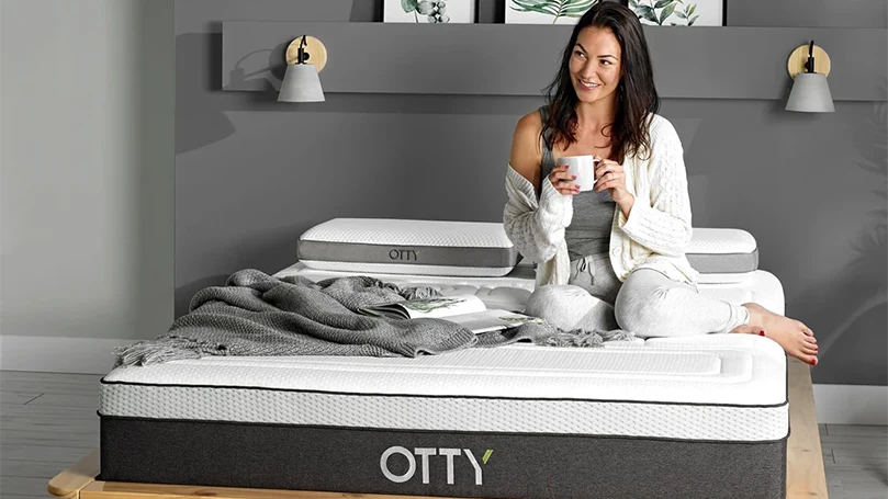 een beeld van een vrouw zittend op een otty pure hybride bamboe & houtskool matras