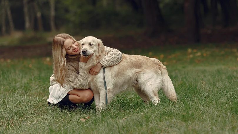 een afbeelding van een vrouw die een hond knuffelt