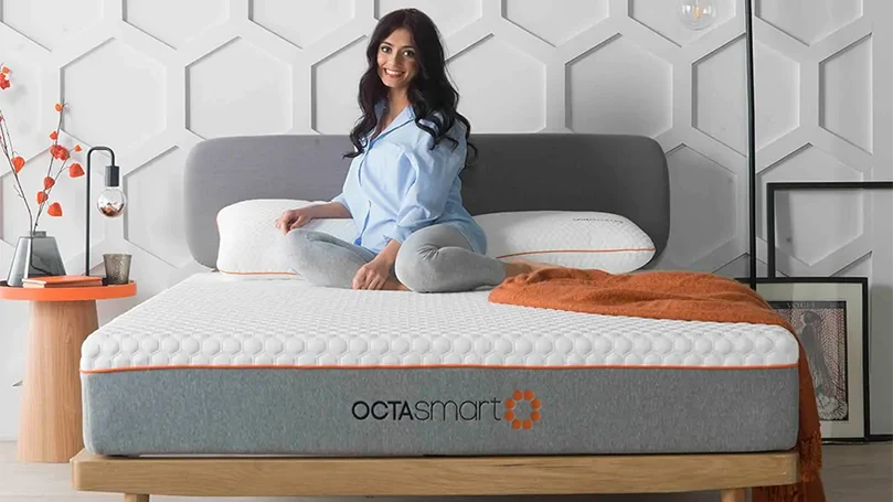 een afbeelding van een vrouw zittend op een Dormeo Octasmart Hybrid matras