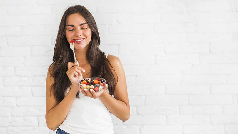 een afbeelding van een jonge vrouw die gezond eet om dromen te onthouden