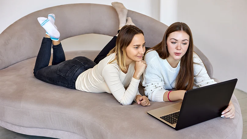 een afbeelding van twee vrouwen liggend op een divanbed