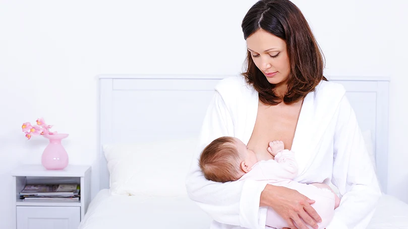 een afbeelding van een vrouw die haar baby borstvoeding geeft