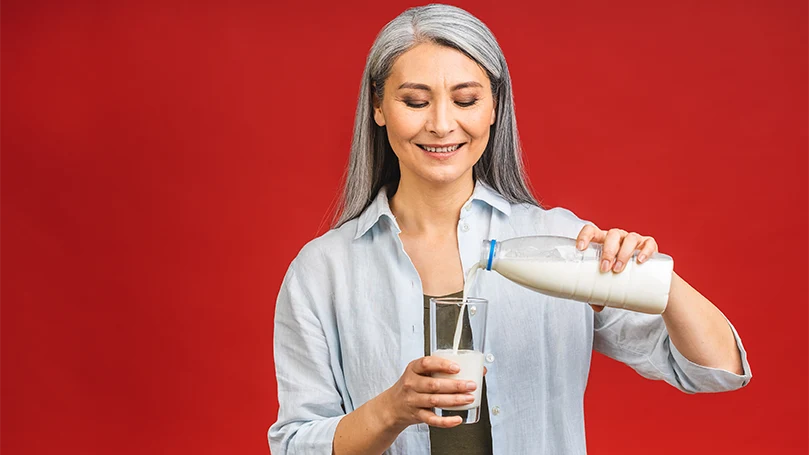 Een afbeelding van een vrouw die een glas melk drinkt.