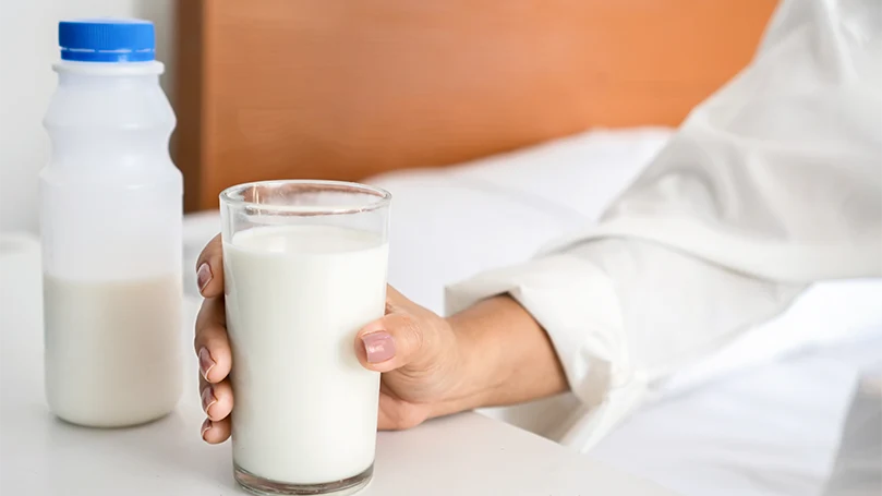 Een afbeelding van Een vrouw die een glas melk vasthoudt.