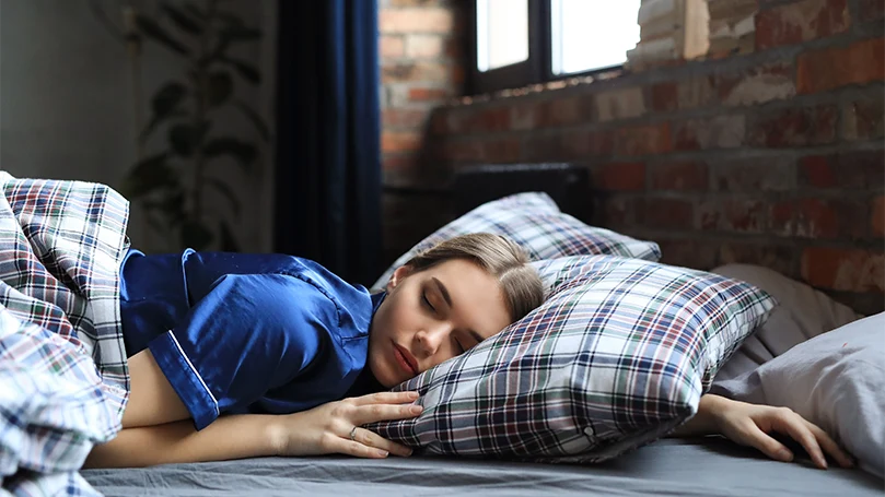 een-jonge-vrouw-slaapt-in-een-bed