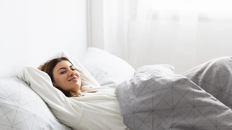 Een ontspannen vrouw in bed.