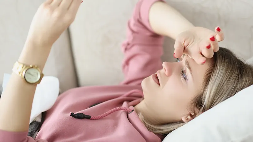 Een afbeelding van een vrouw met opgeheven hoofd in bed.