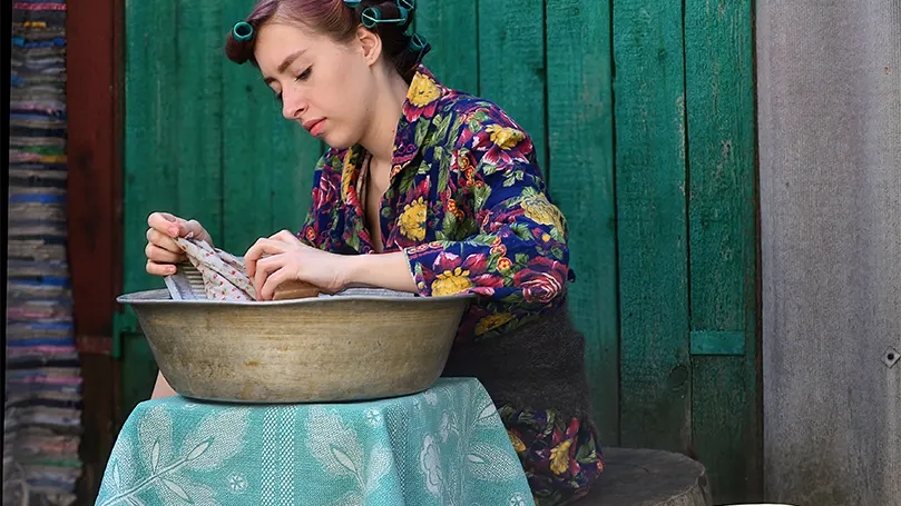 Een afbeelding van een jonge vrouw die haar pyjama in lauw water laat weken.