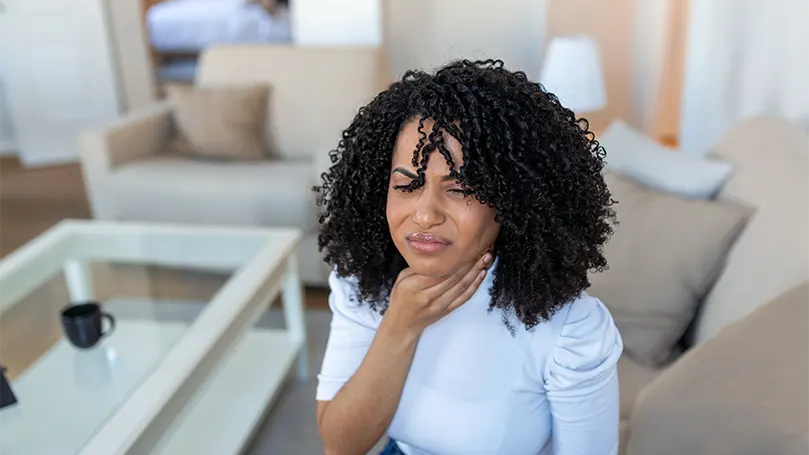 Een afbeelding van een jonge vrouw die lijdt aan zure reflux.