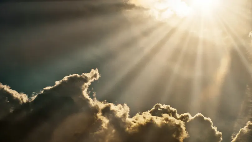 Een beeld van zonlicht dat op enkele wolken schijnt