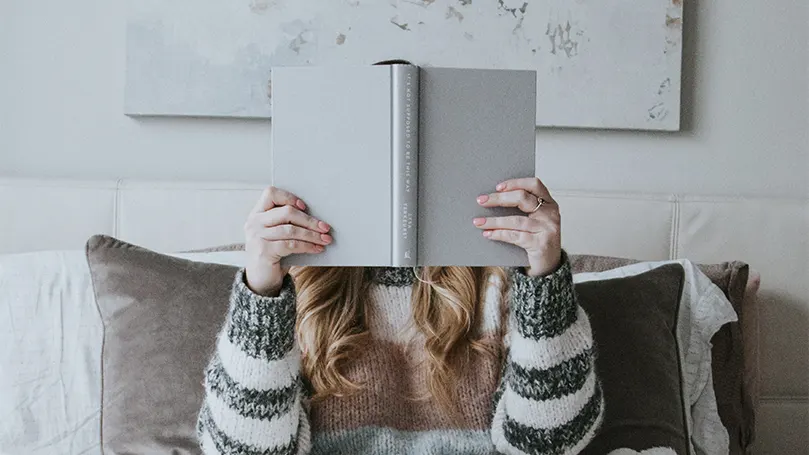 Een afbeelding van een vrouw die een zelfhulpboek leest