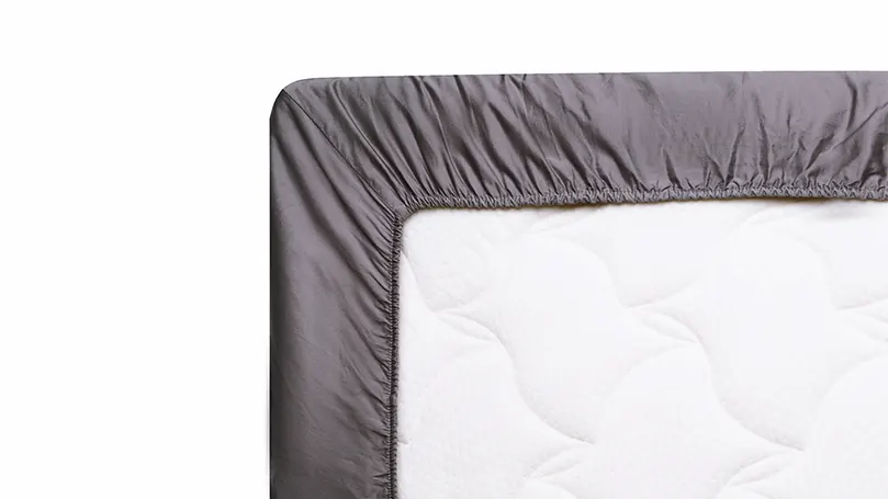 Een afbeelding van een matras in een perfect hoeslaken