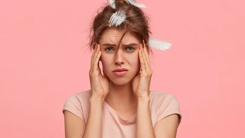 Een afbeelding van een vrouw die niet genoeg geslapen heeft en er ongelukkig uitziet