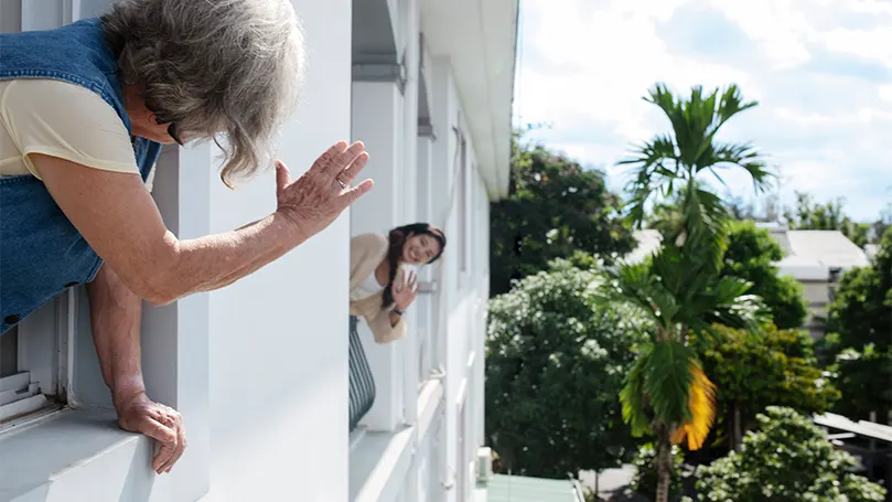 Een afbeelding van een vrouw die naar haar buurvrouw zwaait