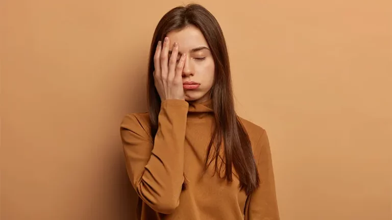 Een afbeelding van een jonge vrouw die een hand boven haar oog houdt