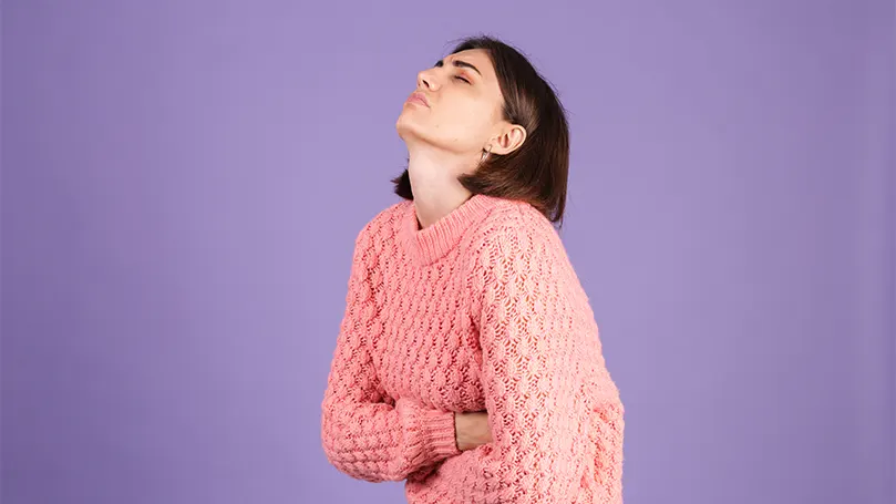 Een vrouw die haar buik vasthoudt van de pijn