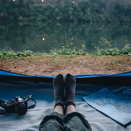 Een vrouw zit in de tent en kijkt naar buiten