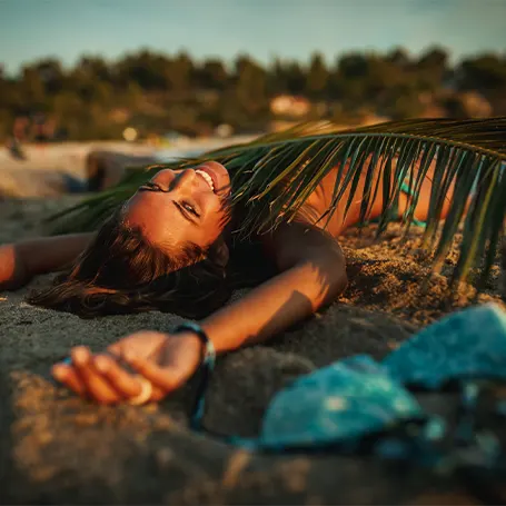 Een jonge vrouw slaapt 's avonds op het strand