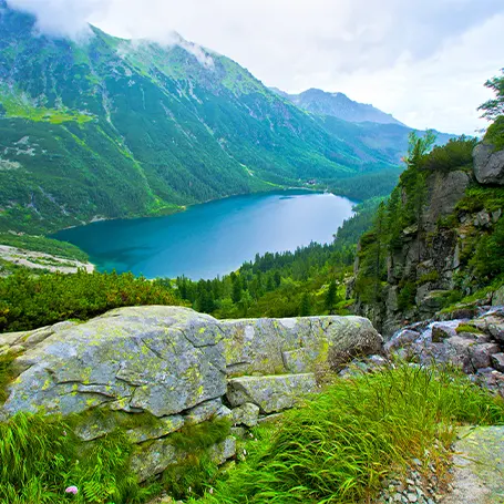 Een beeld van een landschap met bergen en een meer in de verte