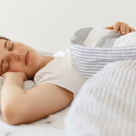 Een afbeelding van een vrouw die slaapt op een matras met goede ondersteuning voor de rug