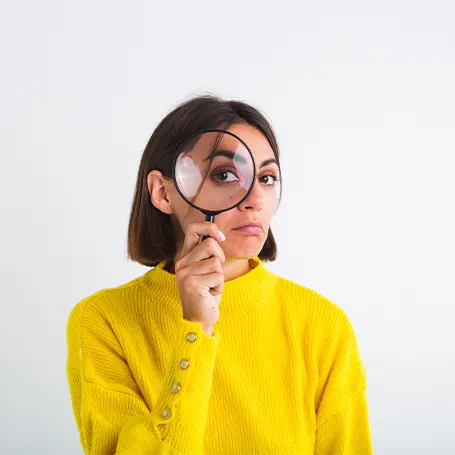 Een afbeelding van een vrouw die door een vergrootglas kijkt