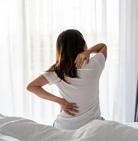 Een afbeelding van een vrouw in bed met rugpijn