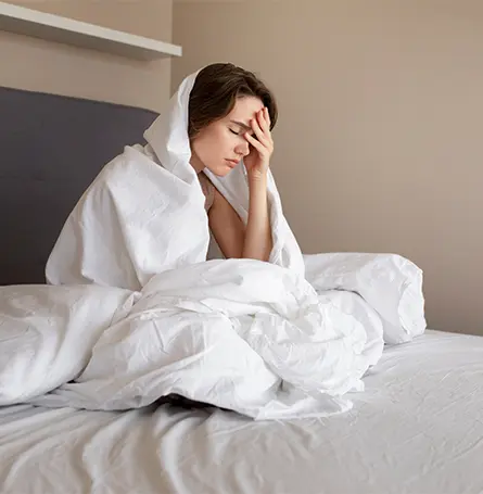 Een afbeelding van een vrouw die net wakker is geworden in bed