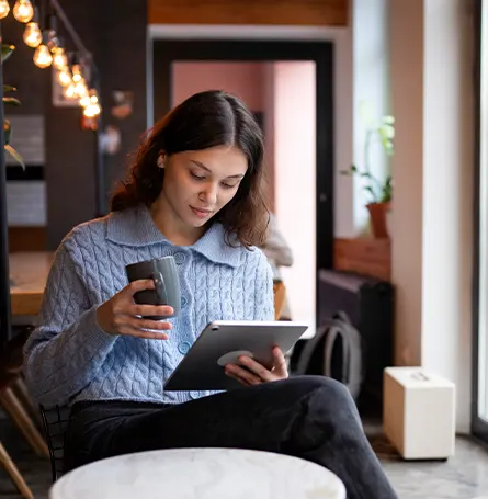 Een afbeelding van een vrouw die van haar tablet leest en op de hoogte blijft